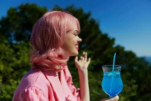 glamour femme avec rose cheveux été cocktail rafraîchissant boisson en buvant de l'alcool photo