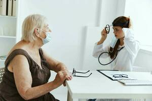 personnes âgées femme portant une médical masque sur examen par une infirmière santé se soucier photo