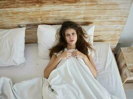 femme mensonges dans lit couvert avec couverture émotions insatisfaction photo