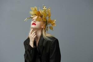 glamour femme d'or feuilles sur le tête dans noir veste studio modèle inchangé photo