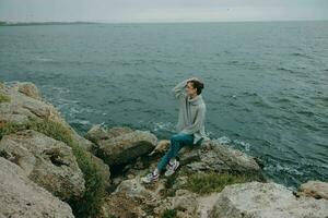 portrait de une femme chandails nuageux mer admiratif la nature relaxation concept photo