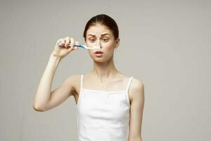 jolie femme dans blanc T-shirt dentaire hygiène santé se soucier lumière Contexte photo