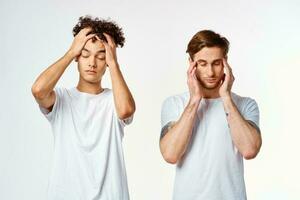deux copains dans blanc t-shirts tenir leur têtes émotions photo