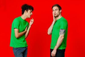 deux Hommes dans vert t-shirts supporter suivant à la communication relation amicale rouge Contexte photo