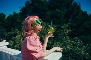 Enchanté Jeune fille avec rose cheveux été cocktail rafraîchissant boisson content femelle relaxant photo