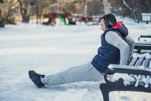 adulte homme est exercice sur le parc dans l'hiver. photo