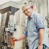 Sénior homme en fonctionnement une du vin réservoir dans le vignoble photo