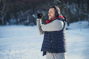 adulte homme est élongation dans le parc dans l'hiver. photo