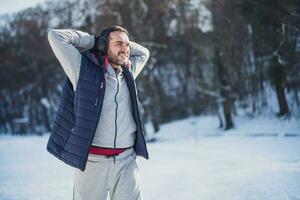 adulte homme est élongation dans le parc dans l'hiver. photo