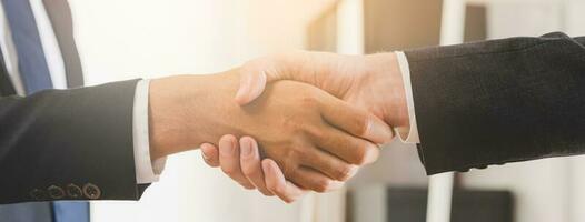 réussi asiatique Jeune homme, Masculin Partenariat, travail en équipe poignée de main ou salutation ensemble à Bureau après projet fait, bien accord. content affaires personnes, ouvrier ou groupe réunion, tremblement mains concept. photo