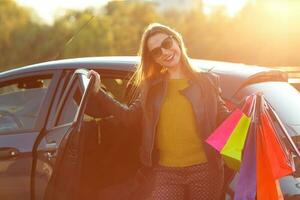 souriant caucasien femme en mettant sa achats Sacs dans le voiture photo