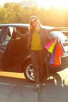 souriant caucasien femme en mettant sa achats Sacs dans le voiture photo