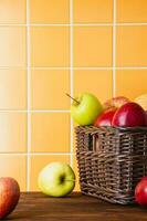 rouge et Jaune pommes dans une panier sur une en bois table photo