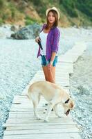 femme avec une chien sur une marcher sur le plage photo