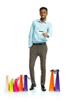 content africain américain homme avec achats Sacs et en portant crédit carte sur blanc Contexte photo