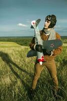 gars dans ancien vêtements pilote avec un avion modèle en plein air photo