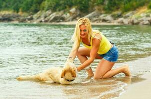 femme avec chien en jouant sur le plage photo