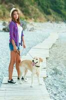 femme avec une chien sur une marcher sur le plage photo