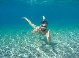 barbe homme avec masque plongée dans une bleu nettoyer l'eau photo