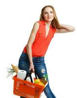 content femme en portant une panier plein de en bonne santé aliments. achats photo