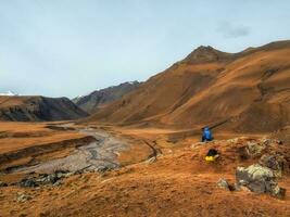 le rêver promeneur est assis sur une grand rocher et Heureusement regards int photo