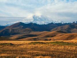 l'automne Montagne plateau, pittoresque Matin ensoleillé voir. vue de le neigeux elbrus volcan dans l'automne. Russie, le Caucase. photo