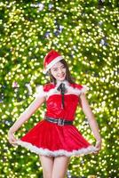 jolie asiatique fille dans Père Noël costume pour Noël avec nuit lumière photo