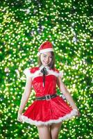 jolie asiatique fille dans Père Noël costume pour Noël avec nuit lumière photo