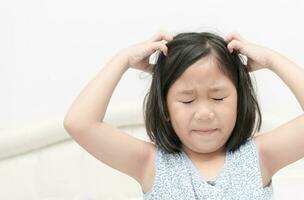 enfant avec taches de rousseur scratch le sien cheveux pour tête les poux photo