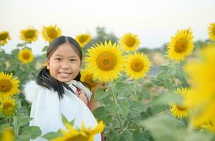 content mignonne asiatique fille sourire avec tournesol, photo