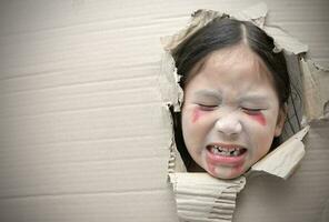 fantôme enfant triste et par trou sur papier carton. photo