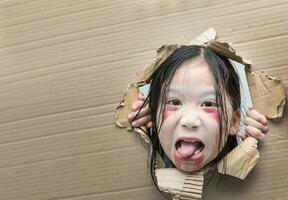 fantôme enfant à la recherche par trou sur papier carton. photo