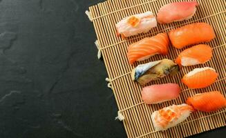 proche en haut de sashimi Sushi ensemble sur noir pierre Contexte photo