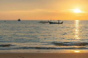 pêche bateau pendant le coucher du soleil dans Thaïlande photo