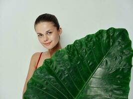 jolie femme paume feuille sourire rouge maillot de bain studio photo