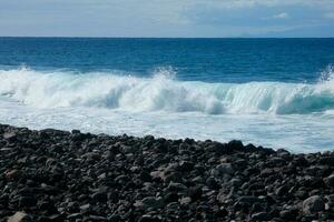 grand vagues s'écraser contre le rochers dans le océan photo