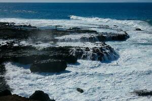 grand vagues s'écraser contre le rochers dans le océan photo