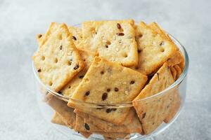 délicieux en bonne santé biscuits craquelins avec lin des graines et sésame des graines sur une plaque. Contexte de une en bonne santé casse-croûte nourriture, proche en haut. photo