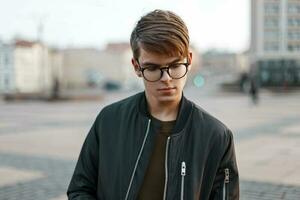 Beau Jeune homme avec des lunettes sur le Contexte de le ville photo