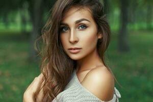 portrait de une jolie femme avec incroyable bleu yeux avec le coiffure dans le parc. photo