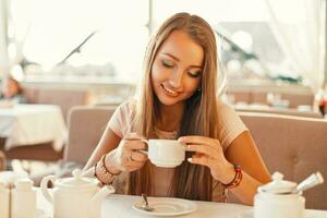 femme avec une sourire en buvant thé dans le restaurant. photo