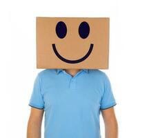 homme permanent avec une papier carton boîte sur le sien tête avec smiley visage photo