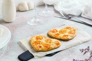 deux cœur en forme de pizzas sur papier sur une ensemble table pour la Saint-Valentin journée fête photo