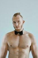 portrait de Beau caucasien athlétique Jeune homme aux seins nus dans cuir arc cravate. aptitude, musculation photo