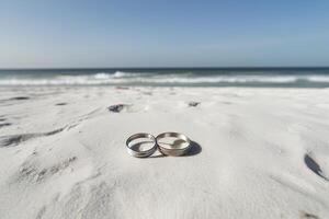 deux mariage anneaux dans le le sable sur le Contexte de une plage et mer. ai généré photo