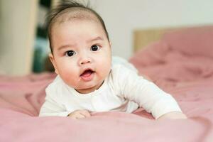 image de une nouveau née bébé mensonge sur une rose lit photo