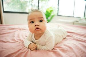 image de une nouveau née bébé mensonge sur une rose lit photo