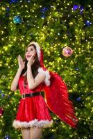 jolie asiatique fille dans Père Noël costume pour Noël avec nuit lumière photo