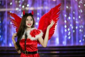 jolie asiatique fille dans Père Noël costume pour Noël avec nuit lumière photo