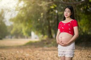 image de femme enceinte touchant son ventre avec les mains photo